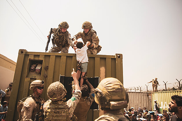 Britští, turečtí a američtí vojáci pomáhají Afgháncům se dostat k evakuaci z...
