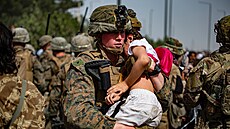 Příslušník americké námořní pěchoty přenáší afghánskou dívku od brány...