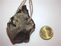 Děravý baltický pazourek jako amulet (s mincí pro srovnání)