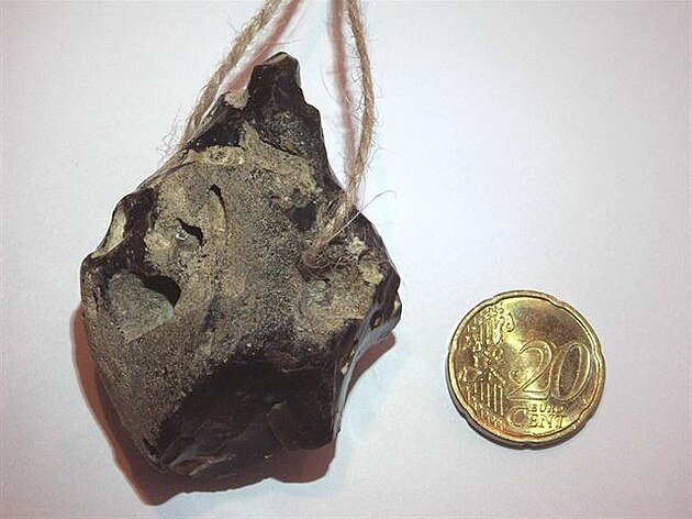 Dravý baltický pazourek jako amulet (s mincí pro srovnání)
