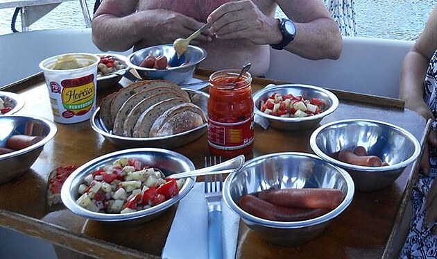 Míchaný salát, párky s hocicí a ajvarem. Vaení na lodi, Chorvatsko.