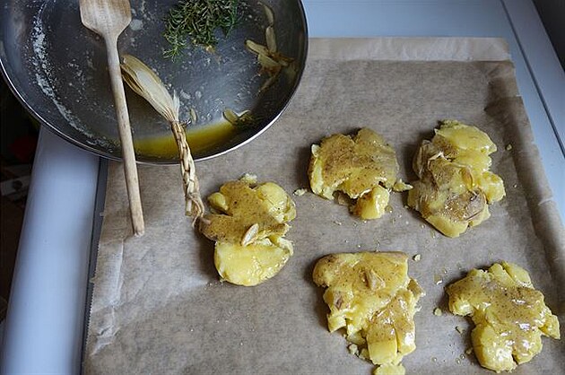Rozpláclé brambory na plechu poádn promastíme okoenným máslem a esnekem